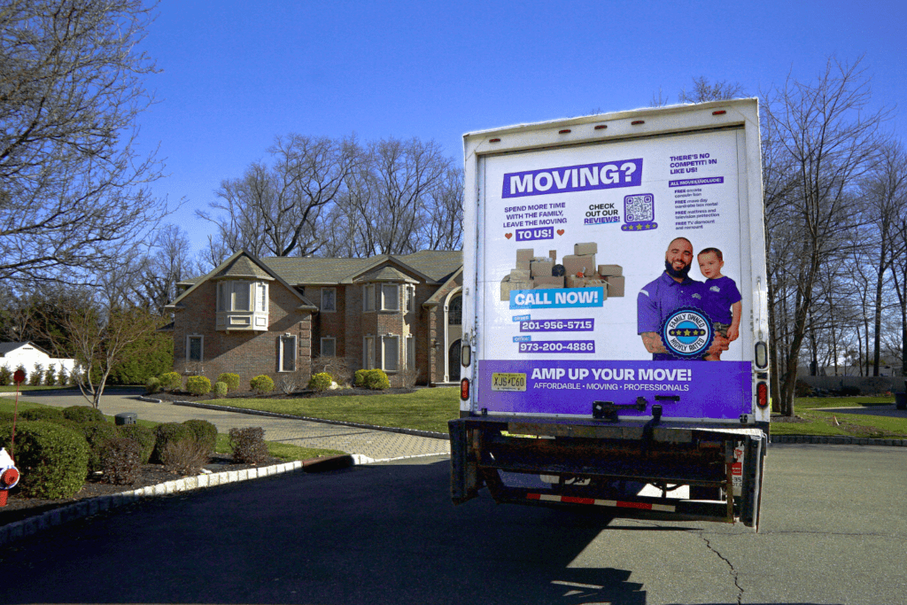 semi truck with amplified moving branding parked in front f a large house.