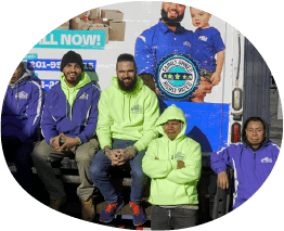 Five team members posing at the back of an amplified moving branded truck