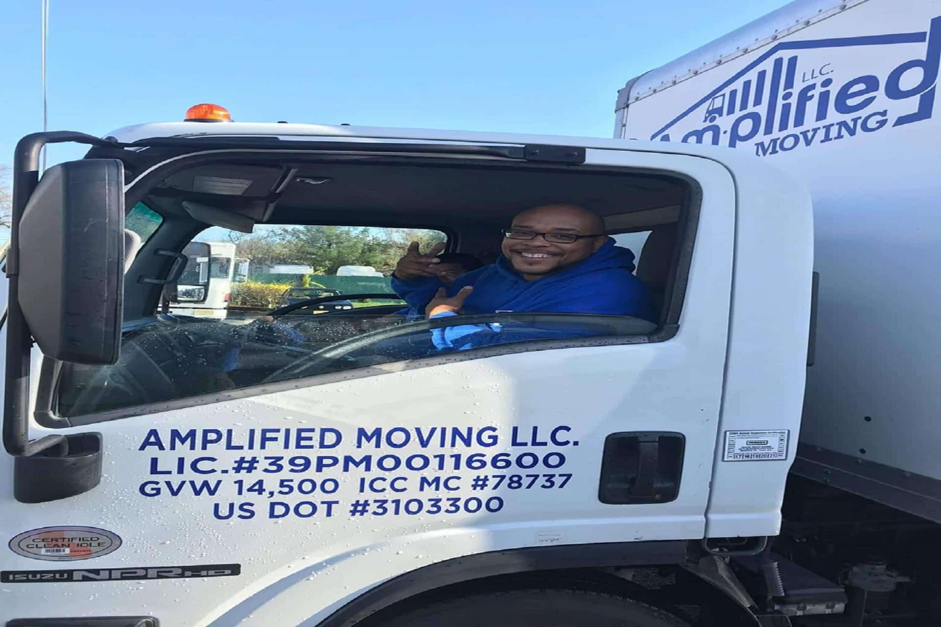 Happy person saying hi from the window of a parked truck.