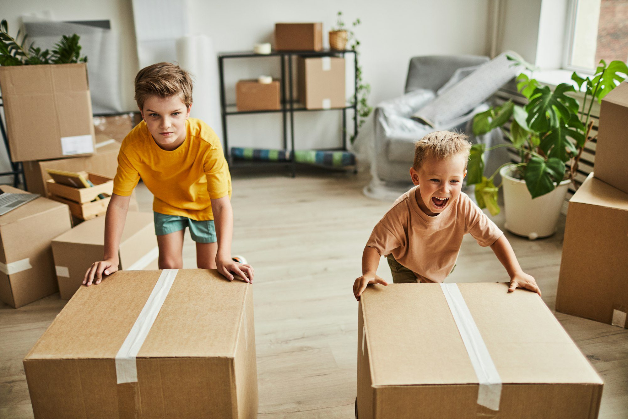 Boys Moving Boxes in a New House