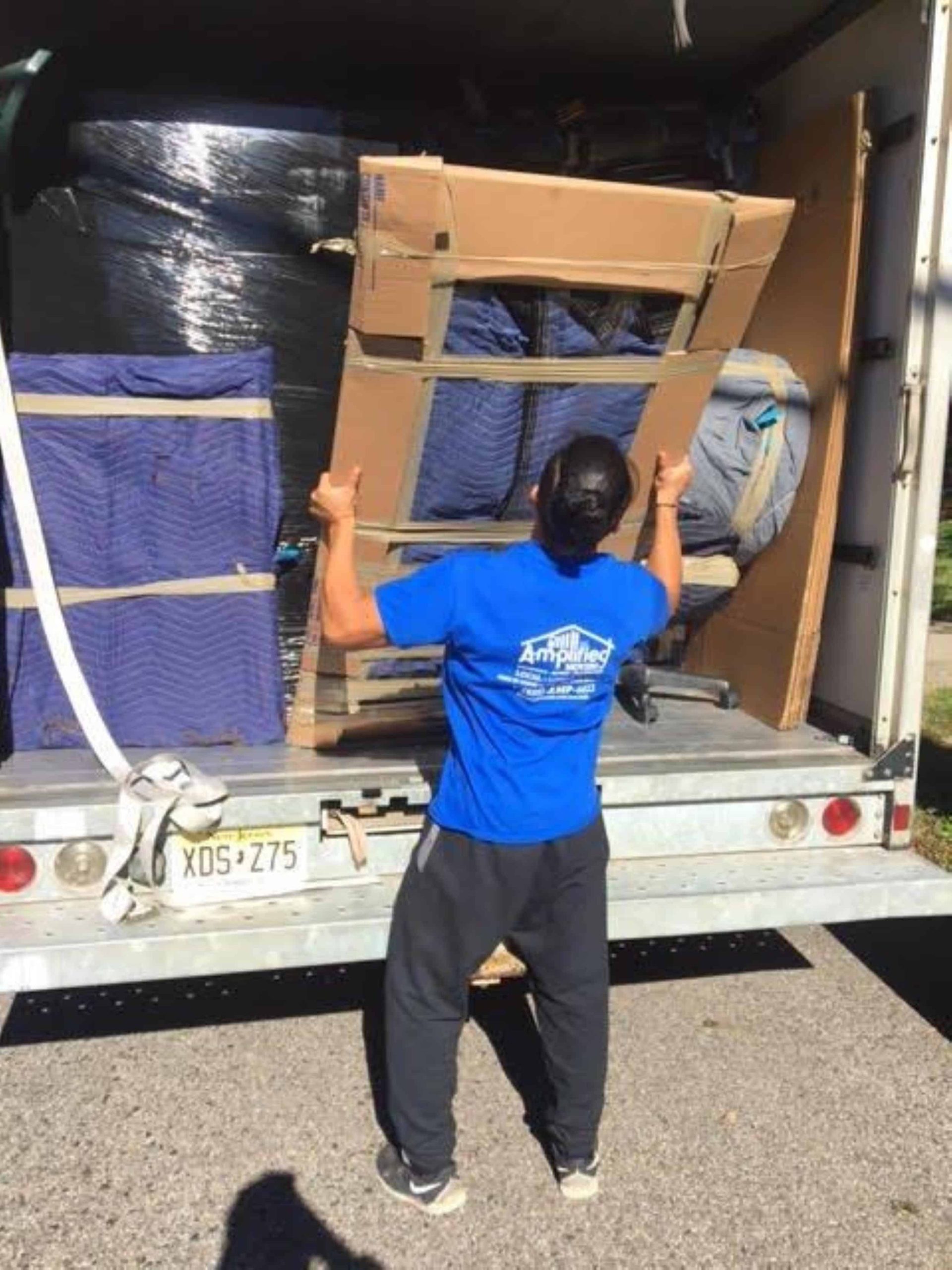 Amplified moving team member carefully unloading items from a truck.